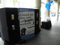 A shot of the back of the booth at the ScamNet launch showing the WA Scamnet poster recommending people visit the website