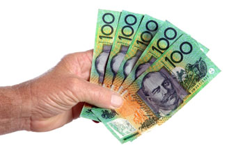 A hand holding five Australian $100 notes