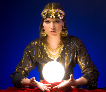 A woman dressed like a gypsy fortune tellerwith gold jewellery and a glowing crystal ball 