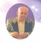 A color photograph of the Proffessor in a circle of white stars on a purple background