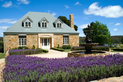 A pretty stone cottage set amidst lavender with a fountain out the front 