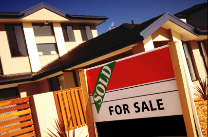 A modern house with a sold sign outside the front