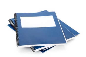 A pile of blue spiral bound notebooks